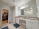 Main bathroom featuring double vanity, granite countertops, tiled floors, and a walk-in closet at 318 Briarbrook Ln, Haines City, FL 33844