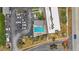 An aerial view showcases the community pool area next to the condo building, surrounded by lush landscaping and parking at 3180 Ocean Shore Blvd # 407, Ormond Beach, FL 32176