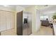 Hallway view features pantry and refrigerator with living area and sliding doors to outside at 3180 Ocean Shore Blvd # 407, Ormond Beach, FL 32176