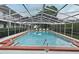 Community pool featuring a screened enclosure, brick trim, and ample seating at 320 Lakeview St # 208, Orlando, FL 32804