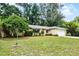 Well-kept single-story home with a lush green lawn, mature trees, and an attached two-car garage at 327 Ketch Ct, Orlando, FL 32835
