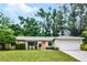 Charming single-story home featuring a well-maintained lawn, mature trees, and a welcoming front entrance at 327 Ketch Ct, Orlando, FL 32835