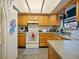 Well-lit kitchen with wood cabinets, gray countertops and tile flooring at 35724 Dawn Dr, Leesburg, FL 34788