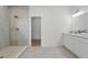 Modern bathroom boasts a walk-in shower with gray tile, white cabinets, and sleek fixtures at 459 Cinnamon Dr, Kissimmee, FL 34759