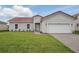 Charming single-story home with a red tile roof, well-manicured lawn, and a two car garage at 459 Cinnamon Dr, Kissimmee, FL 34759