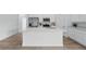 Bright kitchen featuring white cabinetry, stainless steel appliances, a large island with quartz countertops, and modern vinyl flooring at 459 Cinnamon Dr, Kissimmee, FL 34759