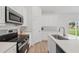 Modern kitchen featuring stainless steel appliances, white cabinetry, a sleek faucet, and vinyl flooring at 459 Cinnamon Dr, Kissimmee, FL 34759