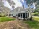 Spacious backyard with a screened-in patio area and lush greenery surrounding the property at 4652 Oak Arbor Cir, Orlando, FL 32808