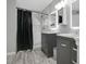 Updated bathroom with dual sinks, gray cabinets, and a tiled shower behind a black curtain at 468 Wexdon Ct, Lake Mary, FL 32746