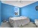Bright blue bedroom with a large window, a comfortable bed, and a view of the outside at 468 Wexdon Ct, Lake Mary, FL 32746