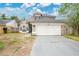 Two-story home featuring neutral paint, a two-car garage, arched windows, and a well-maintained roof in a suburban setting at 468 Wexdon Ct, Lake Mary, FL 32746