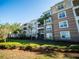 Charming apartment complex exterior with balconies and lush landscaping against a clear blue sky at 4816 Cayview Ave # 20111, Orlando, FL 32819