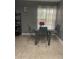 Dining room with a glass table, padded chairs, tiled floor, and natural light from the window at 4843 Pierce Arrow Dr, Apopka, FL 32712