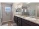 Bathroom featuring double sinks, granite countertop, large mirror, and a glass-door shower at 490 Pentas Ln, Haines City, FL 33844