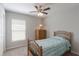Cozy bedroom featuring a ceiling fan, carpet, and a window for natural light at 490 Pentas Ln, Haines City, FL 33844