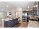 Modern kitchen featuring stainless steel appliances, dark wood cabinets, and an island with marble countertop at 490 Pentas Ln, Haines City, FL 33844