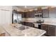 Modern kitchen featuring stainless steel appliances, dark wood cabinets, and an island with marble countertop at 490 Pentas Ln, Haines City, FL 33844