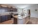 Modern kitchen featuring dark cabinets, stainless appliances, and a center island with a sink, seamlessly connects to dining at 490 Pentas Ln, Haines City, FL 33844