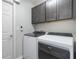 Laundry room featuring new appliances, wood-look floors, and dark gray cabinets at 490 Pentas Ln, Haines City, FL 33844