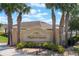 Community sign for Highland Meadows surrounded by mature palm trees, shrubs, and an American flag at 490 Pentas Ln, Haines City, FL 33844