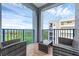 Outdoor balcony featuring wicker furniture and a blue railing, with a view of the sky and trees at 5300 S Atlantic Ave # 5507, New Smyrna Beach, FL 32169