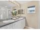 Bathroom featuring double sinks, granite countertop, white cabinets, and a walk-in shower at 5300 S Atlantic Ave # 5507, New Smyrna Beach, FL 32169