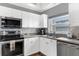 Well-lit kitchen featuring white cabinetry, modern stainless-steel appliances and tiled backsplash at 5300 S Atlantic Ave # 5507, New Smyrna Beach, FL 32169
