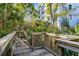Wooden boardwalk leading to building with mature trees and Florida foliage at 5300 S Atlantic Ave # 5507, New Smyrna Beach, FL 32169