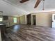 Open floor plan seamlessly connects the kitchen and living areas with wood-look floors and neutral walls at 56048 Blue Creek Rd, Astor, FL 32102