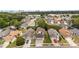 Aerial view showcases a neighborhood with mature trees and manicured lawns under a blue sky at 5672 Parkview Lake Dr, Orlando, FL 32821