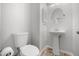 Clean half-bathroom with pedestal sink, toilet, and decorative mirror at 5672 Parkview Lake Dr, Orlando, FL 32821