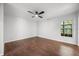 Neutral bedroom with hardwood flooring, a ceiling fan, window and white walls at 5672 Parkview Lake Dr, Orlando, FL 32821