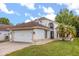 Charming single-Gathering home with a well-manicured lawn, two car garage, and tropical landscaping on a sunny day at 5672 Parkview Lake Dr, Orlando, FL 32821