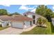 Charming single-Gathering home with a well-manicured lawn, two car garage, and tropical landscaping on a sunny day at 5672 Parkview Lake Dr, Orlando, FL 32821