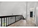 Upstairs hallway featuring wood-look floors and modern railings at 5672 Parkview Lake Dr, Orlando, FL 32821
