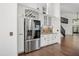 Modern kitchen featuring stainless steel refrigerator, custom cabinets, wine rack, granite countertops, and mosaic backsplash at 5672 Parkview Lake Dr, Orlando, FL 32821