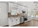 Beautiful kitchen featuring granite countertops, stainless steel appliances, white cabinetry, and a mosaic backsplash at 5672 Parkview Lake Dr, Orlando, FL 32821