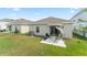 Backyard featuring a patio with outdoor seating, a shaded swing, and a well-maintained lawn at 6834 Wilson Hammock Ave, Groveland, FL 34736