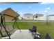 Relaxing backyard featuring a patio with seating, a shaded swing, and green lawn at 6834 Wilson Hammock Ave, Groveland, FL 34736
