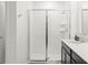 Bright bathroom featuring glass shower doors, tile surround, and vanity with solid surface countertop at 6834 Wilson Hammock Ave, Groveland, FL 34736