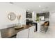 Open kitchen with dining area featuring black cabinets, white countertops, and seating at the island at 6834 Wilson Hammock Ave, Groveland, FL 34736
