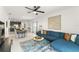 Open-concept living space featuring a blue sofa, dining area, and partial view of the adjacent kitchen at 6834 Wilson Hammock Ave, Groveland, FL 34736
