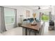 Bright living space with a modern table set, blue sectional sofa, and sliding glass doors to the backyard at 6834 Wilson Hammock Ave, Groveland, FL 34736