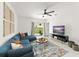 Comfortable living room featuring a blue sectional sofa, area rug, TV, and sliding door access to the backyard at 6834 Wilson Hammock Ave, Groveland, FL 34736