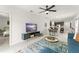 Open-concept living space with a modern TV stand, view of the kitchen, and comfortable living area at 6834 Wilson Hammock Ave, Groveland, FL 34736