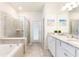 Bright bathroom features a soaking tub, glass shower, and a dual sink vanity at 7224 Oakmoss Loop, Davenport, FL 33837