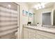 Bathroom featuring double sinks with granite counters and tiled shower with curtain at 7224 Oakmoss Loop, Davenport, FL 33837