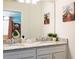 Bathroom with double vanity, granite countertops, and tropical decor at 7224 Oakmoss Loop, Davenport, FL 33837