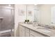 Bathroom featuring double sinks with granite counters and tiled shower with glass doors at 7224 Oakmoss Loop, Davenport, FL 33837