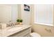 Well-lit powder room with granite countertop, modern fixtures, and a decorative mirror at 7224 Oakmoss Loop, Davenport, FL 33837